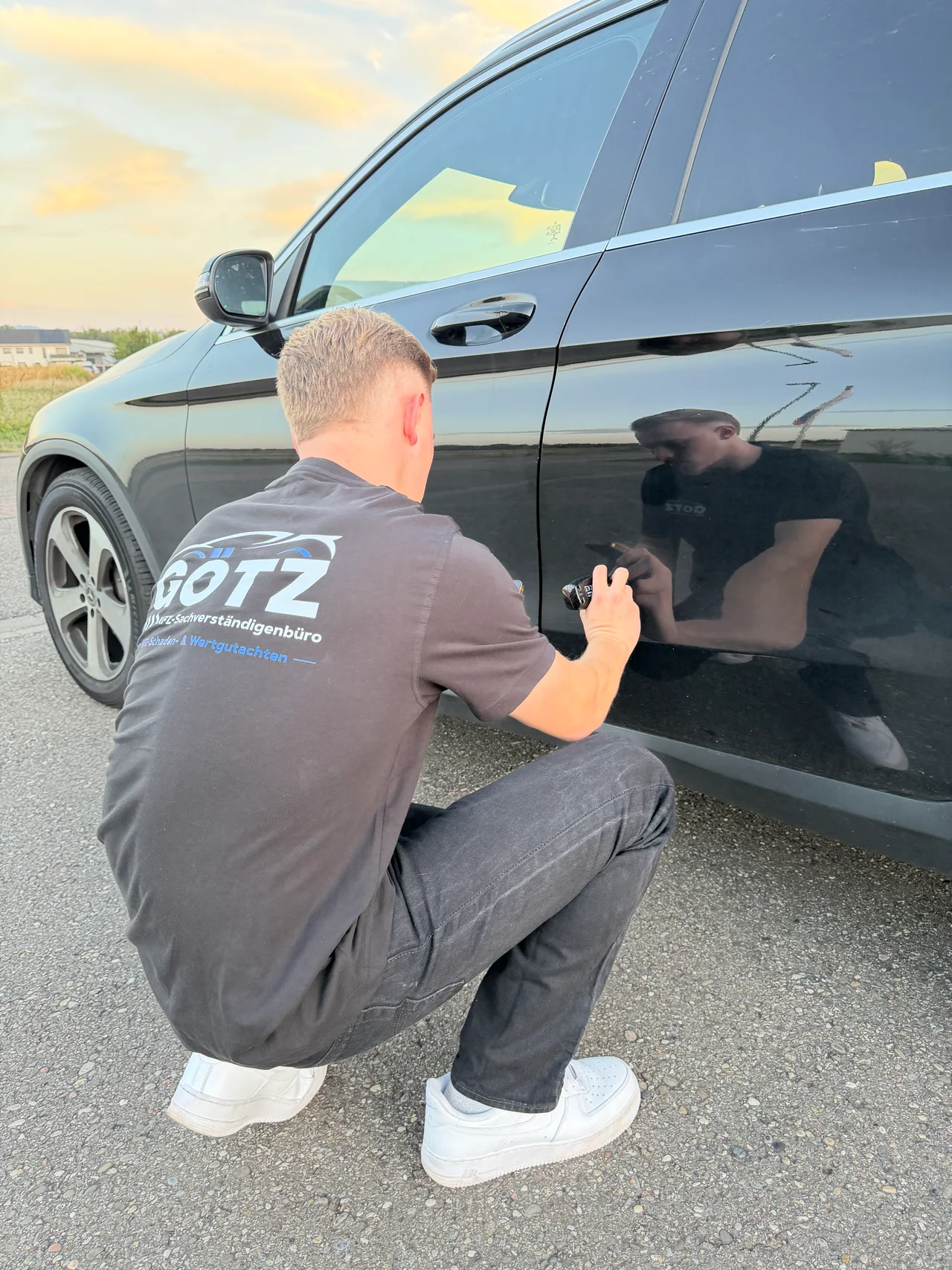 Jeremy Götz misst die Lackschichtdicke am Fahrzeug